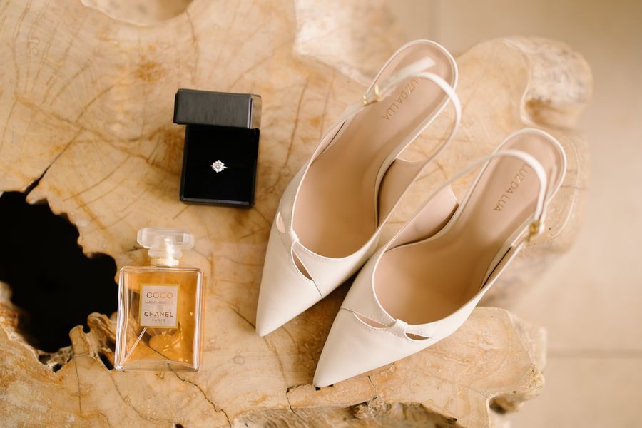 Zapatos de novia, anillo y perfume sobre madera