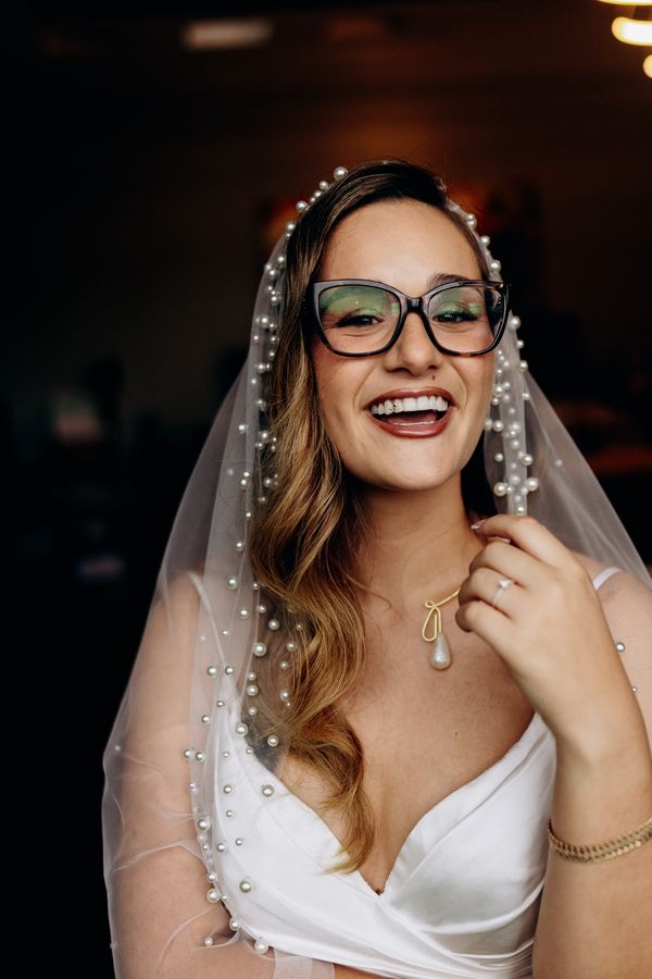 Novia con velo de perlas riendo