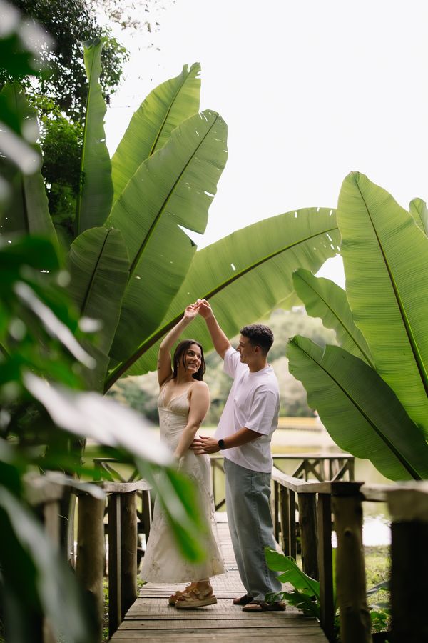 Pareja bailando bajo hojas de platanillo