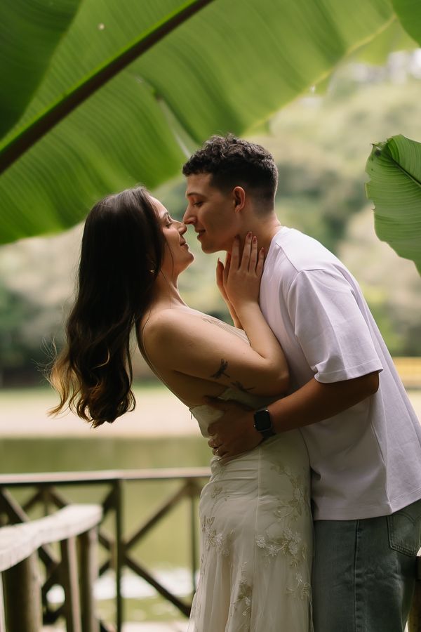 Pareja a punto de besarse bajo una hoja