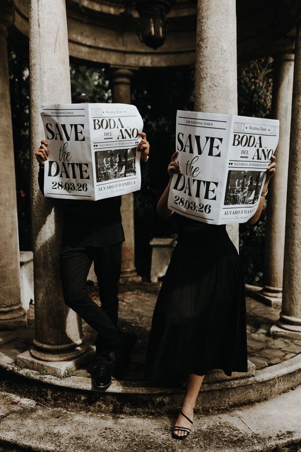 Pareja sosteniendo periódicos de save the date